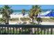 Balcony view of palm trees, sandy beach, Gulf Coast waters, a large water slide, and beach chairs at 5500 Gulf Blvd # 4226, St Pete Beach, FL 33706