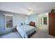 Bedroom featuring natural light, neutral carpet, ceiling fan and adjacent bath and walk-in closet at 5938 Oakhurst Dr, Seminole, FL 33772
