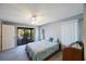 Bedroom with sliding glass doors to screened lanai and view of the pool, ceiling fan, and neutral carpet at 5938 Oakhurst Dr, Seminole, FL 33772