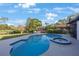 Beautiful in-ground pool features a hot tub, tropical landscaping, and patio seating, perfect for entertaining guests at 5938 Oakhurst Dr, Seminole, FL 33772