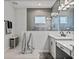 Well-lit bathroom featuring dual sinks, sleek fixtures, and a tiled shower at 6185 Hidden Branch Dr, Apollo Beach, FL 33572