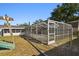 A view of the backyard with a large screened enclosure and swing set at 6712 Runningwoods Dr, Tampa, FL 33634