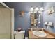 Bathroom with modern lighting, wood vanity, sink, shower over tub and blue walls at 6712 Runningwoods Dr, Tampa, FL 33634
