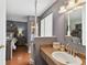 Bathroom sink with wooden vanity next to bedroom with hardwood floors and a gray color scheme at 6712 Runningwoods Dr, Tampa, FL 33634