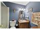 Bathroom with modern lighting, wood vanity, sink, shower over tub and blue walls at 6712 Runningwoods Dr, Tampa, FL 33634