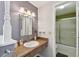 Bathroom with wood vanity, modern lighting, oval sink, and a shower over a tub at 6712 Runningwoods Dr, Tampa, FL 33634