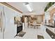 Open-concept kitchen with white cabinets, modern appliances, and an eat-in dining area with white chairs at 6712 Runningwoods Dr, Tampa, FL 33634