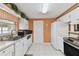 Bright kitchen featuring white cabinets, tile floors, and modern appliances, offering a clean cooking space at 6712 Runningwoods Dr, Tampa, FL 33634
