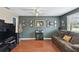 Comfortable living room with hardwood floors, ceiling fan, and personal photos creating a warm and inviting atmosphere at 6712 Runningwoods Dr, Tampa, FL 33634