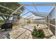 Large screened-in patio with space for outdoor seating, featuring a grilling area and shade trees at 6712 Runningwoods Dr, Tampa, FL 33634
