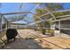 View of large, partially-covered screened patio with outdoor grill and tiled patio area at 6712 Runningwoods Dr, Tampa, FL 33634