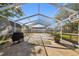 Spacious screened-in patio with a tiled area and grilling station for outdoor enjoyment at 6712 Runningwoods Dr, Tampa, FL 33634