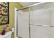 Bathroom shower enclosed by a sliding glass door and featuring olive-green walls at 6712 Runningwoods Dr, Tampa, FL 33634