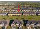 An aerial view showcases tan townhomes with garages and nearby visitor parking, with well-maintained lawns in the community at 7047 Towne Lake Rd, Riverview, FL 33578