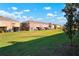 Wide view of the backyard, showing ample green space and neighboring townhomes at 7047 Towne Lake Rd, Riverview, FL 33578
