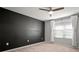 Bedroom featuring a black accent wall, ceiling fan, window with blinds and curtains at 7047 Towne Lake Rd, Riverview, FL 33578