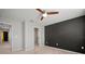Neutral bedroom featuring a ceiling fan, black accent wall, and a walk-in closet for ample storage at 7047 Towne Lake Rd, Riverview, FL 33578