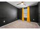 Bedroom with a dark accent wall, ceiling fan and a window with yellow curtains at 7047 Towne Lake Rd, Riverview, FL 33578