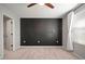 Bedroom featuring neutral carpet, a ceiling fan, a walk-in closet, and a dark accent wall at 7047 Towne Lake Rd, Riverview, FL 33578