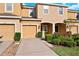 Beautiful tan townhome with attached garage and driveway, complimented by well-manicured landscaping at 7047 Towne Lake Rd, Riverview, FL 33578