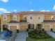 Front exterior view of townhomes with garages, landscaping, and a boat with trailer at 7047 Towne Lake Rd, Riverview, FL 33578