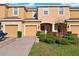 Charming townhome with well-maintained landscaping, tan siding, and attached garages at 7047 Towne Lake Rd, Riverview, FL 33578