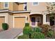 View of front door, attached garage, and beautifully landscaped front yard at 7047 Towne Lake Rd, Riverview, FL 33578