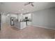 Open concept kitchen features granite island, stainless appliances, white cabinetry and tile flooring at 7047 Towne Lake Rd, Riverview, FL 33578