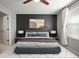 Staged main bedroom featuring a ceiling fan, dark accent wall, bed and decorative pillows at 7047 Towne Lake Rd, Riverview, FL 33578