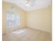 Bright bedroom featuring tile flooring, a ceiling fan, and a large window with sheer curtains letting in natural light at 7116 Colony Pointe Dr, Riverview, FL 33578