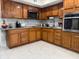 Traditional kitchen with wood cabinetry, stainless steel appliances, and ample counter space for meal preparation at 7126 Oelsner St, New Port Richey, FL 34652