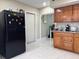 Spacious kitchen featuring a black refrigerator, white cabinets, and a view into an adjacent room at 7126 Oelsner St, New Port Richey, FL 34652