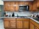 Traditional kitchen with wood cabinetry, stainless steel appliances, and ample counter space for meal preparation at 7126 Oelsner St, New Port Richey, FL 34652