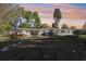 The backyard has a covered patio, a lush green lawn, and a colorful sky at 766 86Th N Ave, St Petersburg, FL 33702