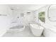 Bathroom featuring a soaking tub, walk-in shower, bright natural light, and marble-look tile at 766 86Th N Ave, St Petersburg, FL 33702