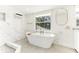 Bathroom featuring a soaking tub, walk-in shower, bright natural light, and marble-look tile at 766 86Th N Ave, St Petersburg, FL 33702