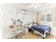 Bright bedroom featuring a bed with a blue blanket, a desk, and a view of the outdoors at 766 86Th N Ave, St Petersburg, FL 33702
