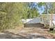 Spacious backyard driveway with a white fence, bordered by lush greenery and trees at 766 86Th N Ave, St Petersburg, FL 33702