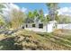 View of the back of the white single-story home with garden beds and lush greenery at 766 86Th N Ave, St Petersburg, FL 33702