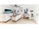 Bright living room featuring neutral furniture, a ceiling fan, and decorative shelving with plants at 766 86Th N Ave, St Petersburg, FL 33702