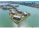 Expansive aerial shot of waterfront condo community featuring a pool, lush greenery, and tranquil water views at 8040 Sailboat Key S Blvd # 402, St Pete Beach, FL 33707