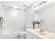 Bright, tidy bathroom with white fixtures, patterned wallpaper, and decorative flower accents at 8040 Sailboat Key S Blvd # 402, St Pete Beach, FL 33707