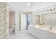 Bathroom featuring double sinks, walk-in shower, adjacent toilet area, and serene views from the window at 8040 Sailboat Key S Blvd # 402, St Pete Beach, FL 33707