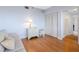 Bright bedroom with a wooden floor, neutral paint, a side table and chair, and a large closet at 8040 Sailboat Key S Blvd # 402, St Pete Beach, FL 33707