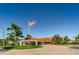 Exterior of community clubhouse flying the American flag, showcasing landscaping and the entrance drive at 8040 Sailboat Key S Blvd # 402, St Pete Beach, FL 33707