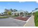 Community entrance gate featuring brick paved roundabout, well-maintained landscaping, and security booth at 8040 Sailboat Key S Blvd # 402, St Pete Beach, FL 33707