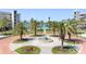 Aerial view of complex entrance and surrounding palms with fountain and community amenities at 8040 Sailboat Key S Blvd # 402, St Pete Beach, FL 33707