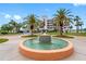 Building exterior with fountain, lush palms, and neatly manicured landscaping at 8040 Sailboat Key S Blvd # 402, St Pete Beach, FL 33707