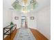 Elegant hallway with a mirrored ceiling, hardwood floors, and decorative console table at 8040 Sailboat Key S Blvd # 402, St Pete Beach, FL 33707