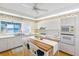 Bright kitchen with white cabinetry, wood floors, and a window overlooking the waterfront at 8040 Sailboat Key S Blvd # 402, St Pete Beach, FL 33707